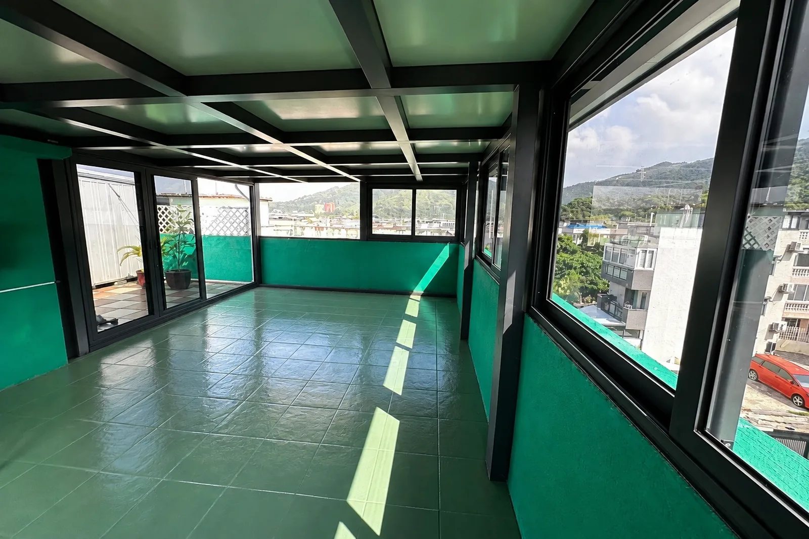 圍封後（室內全景）：棚下空間變成完整房間，趟窗沿矮牆安裝，採光通風兼備。
